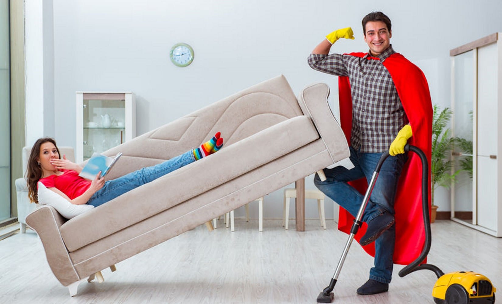 Man tilt bank op om te stofzuigen